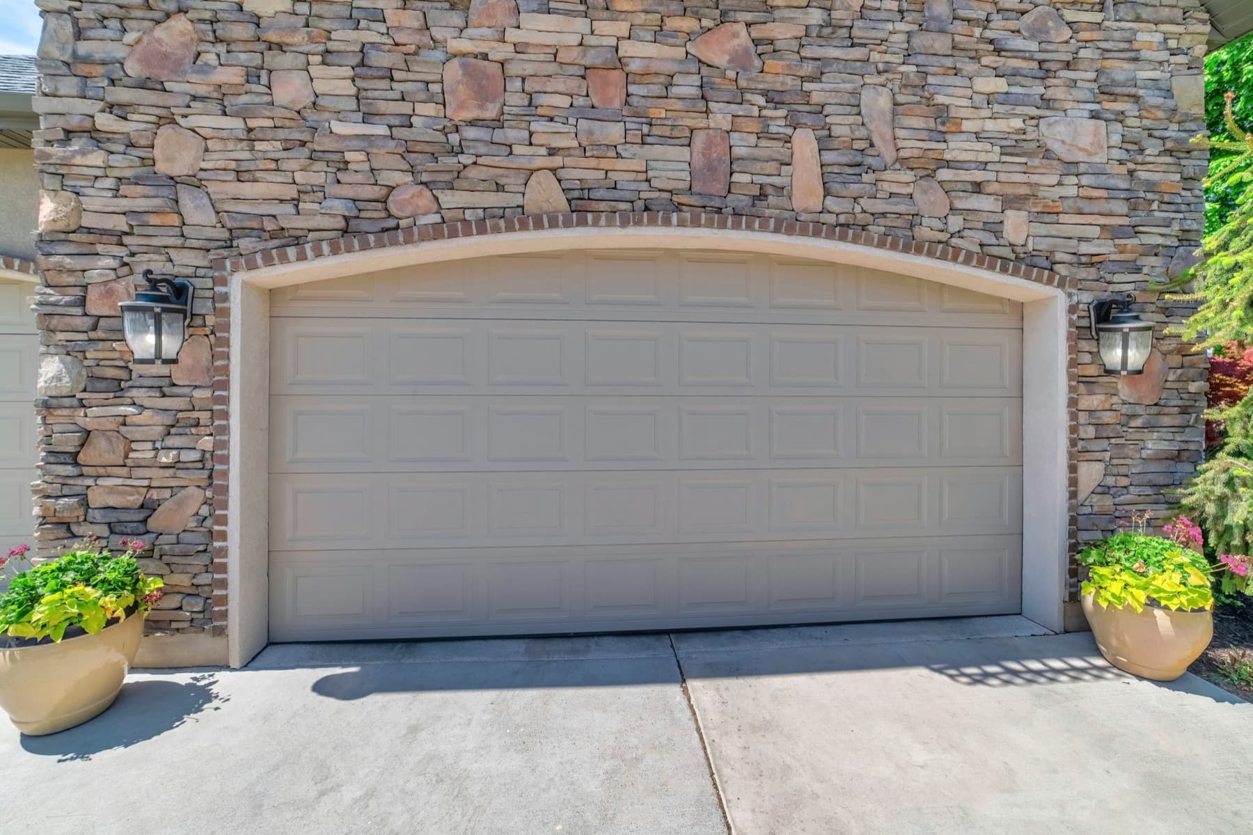 Raised-panel garage door on a stone house